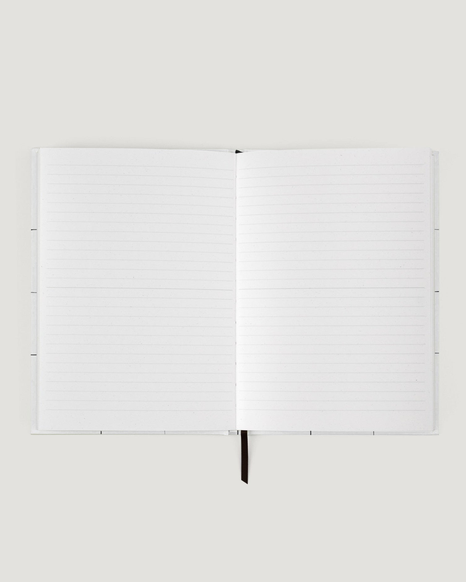 White notebook with a pen on a white background