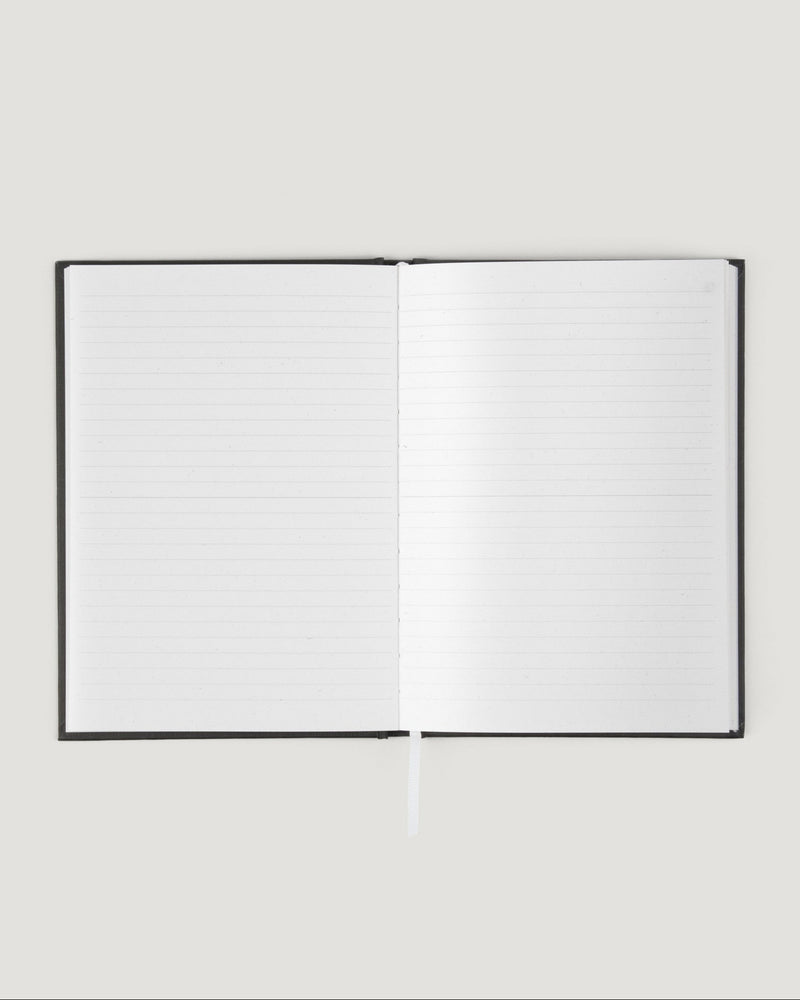 Open notebook with blank pages on a light gray background