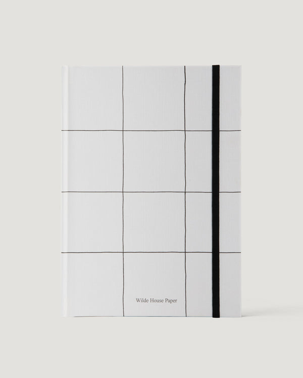 White notebook with grid pattern and black line on a white background