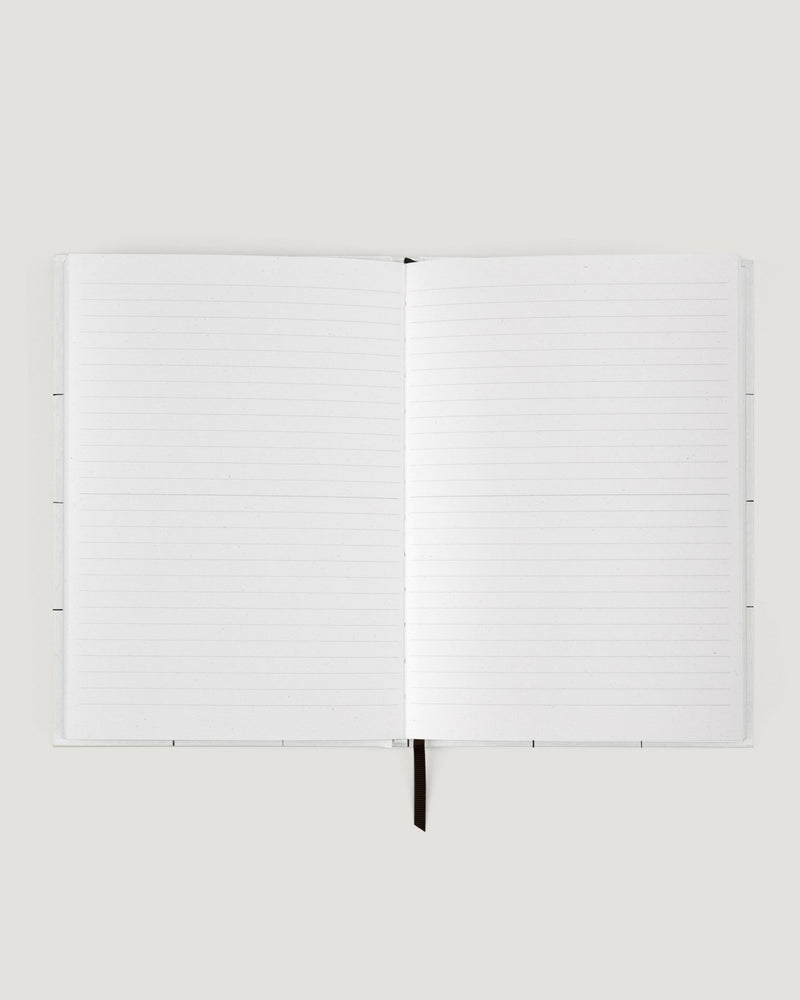 White notebook with a pen on a white background